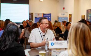 People around a table at a conference talking