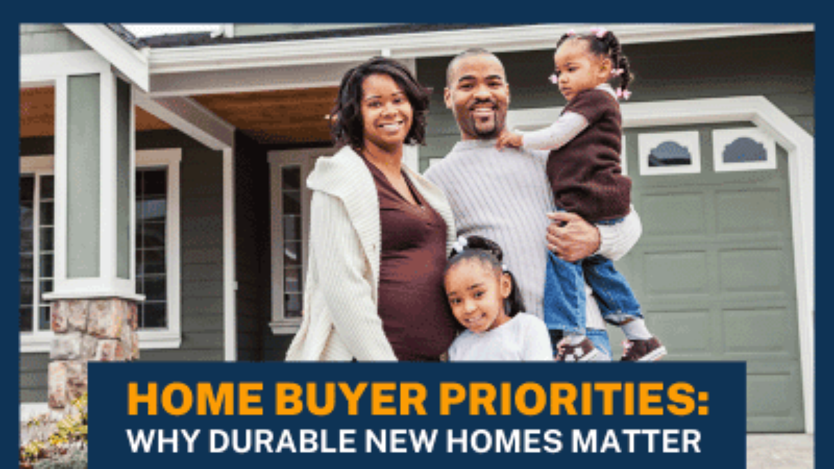 A family of four standing in front of a new home, smiling.